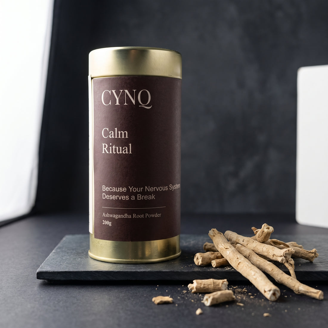 Calm Ritual tin on slate with whole ashwagandha roots and root pieces