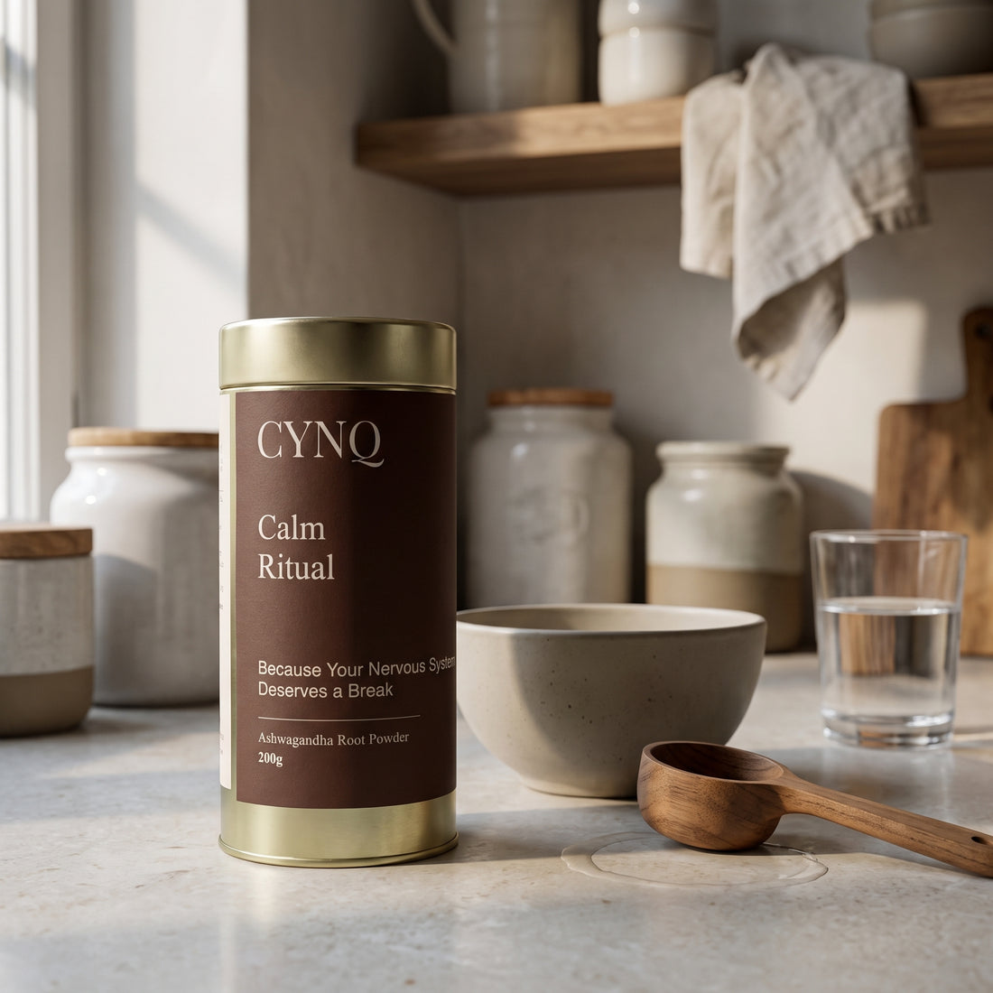 Calm Ritual tin on a kitchen counter with a stoneware bowl, a wooden scoop, a linen cloth and a glass of water