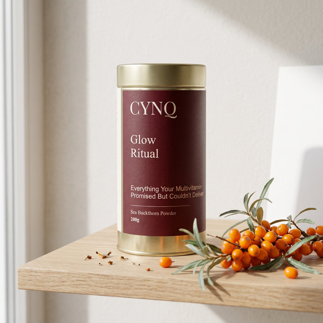 Glow Ritual tin on an oak shelf with a sprig of orange sea buckthorn berries