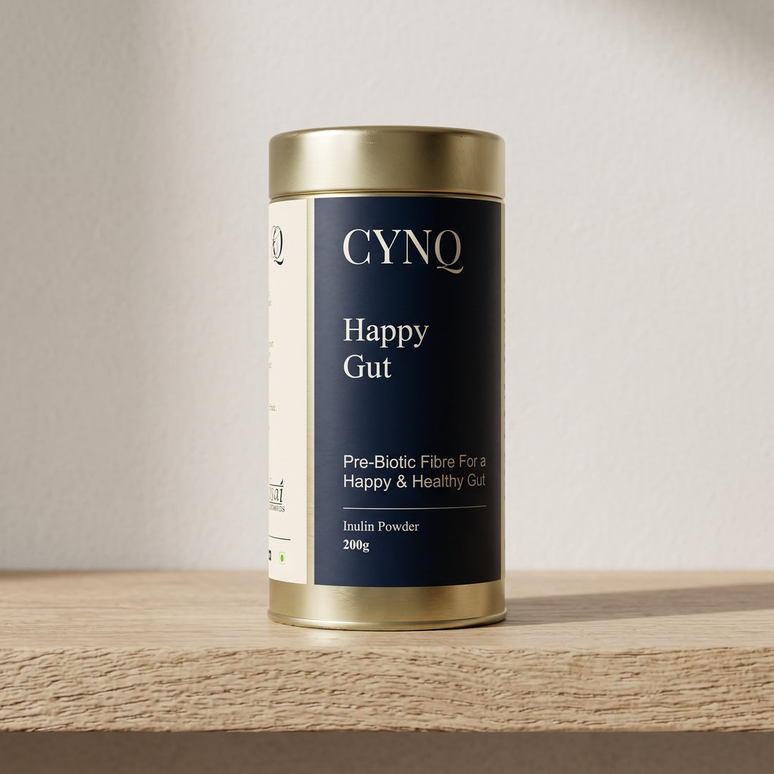 Happy Gut inulin prebiotic fibre in a gold tin with a navy CYNQ label, front view, on an oak shelf