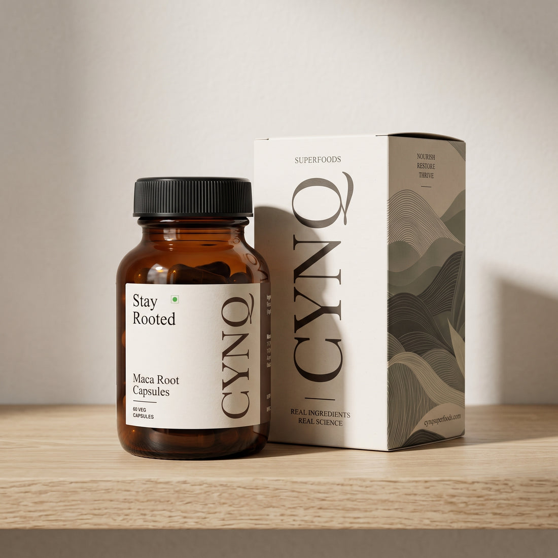 Stay Rooted capsule bottle beside the CYNQ outer box on an oak shelf