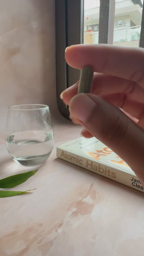Moringa Extract - A hand holding a Moringa extract capsule in a scenic view. CYNQ Green Ritual
